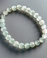 Beaded bracelet with light green beads on a gray background