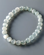Load image into Gallery viewer, Beaded bracelet with light green stones on a gray background
