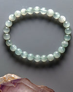 Load image into Gallery viewer, Beaded bracelet with a gray background and a crystal on the side
